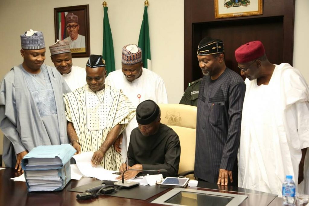 Acting President Yemi Osinbajo signing the 2017 budget