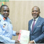 Chief Executive Officer of AIB, Engr Akin Olateru (right) hands over the interim report to Chief of Air Staff (CAS), Air Marshal Amao (left)