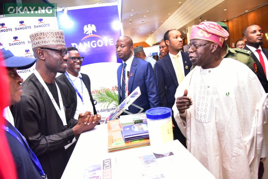 President of Federal Republic of Nigeria, Asiwaju Bola Ahmed Tinubu, discussing with Jibrin Abubakar of Dangote's corporate communications department at the Dangote stand at the ongoing 29th Nigerian Economic Summit in Abuja on 23rd October 2023.