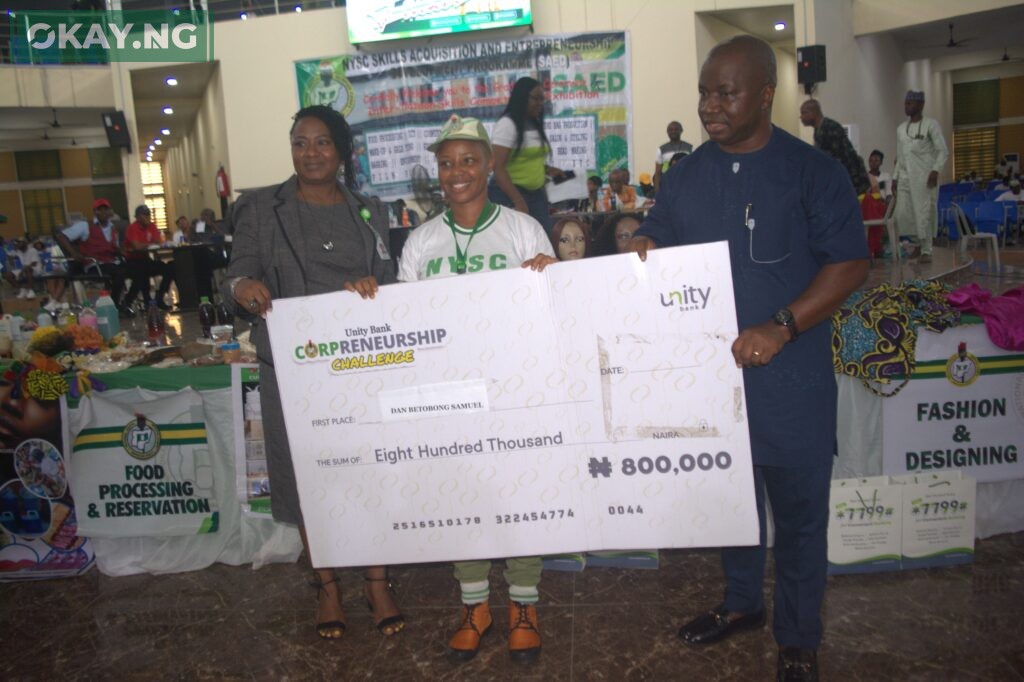 A winner in Rivers NYSC Camp poses with Divisional Head, Retail and SME, Unity Bank, Mrs. Adenike Ambibola and an NYSC official