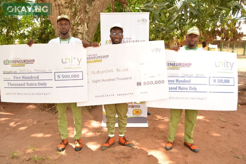 Three of the winners at Delta NYSC Orientation camp pose for a photo with their cheques after emerging as winners